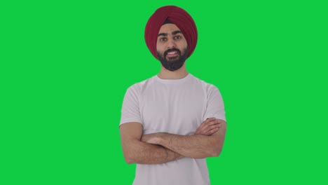 happy sikh indian man standing crossed hands green screen