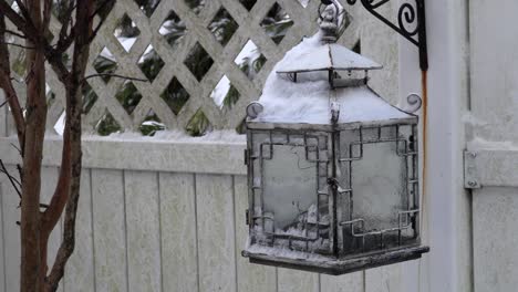 tight shot of a frozen ornate birdhouse in a winter blizzard wonderland
