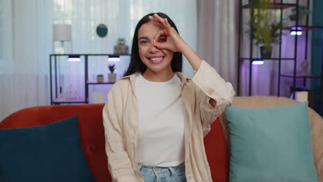 Happy-cheerful-young-woman-looking-approvingly-at-camera-showing-ok-gesture,-positive-like-sign