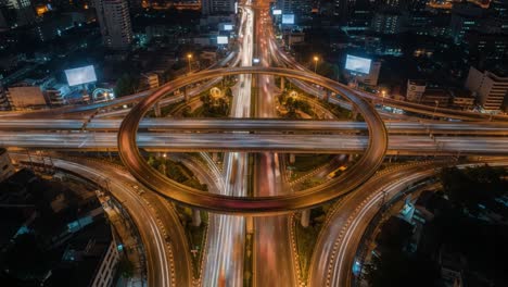 nighttime aerial view of a busy highway interchange with light trails