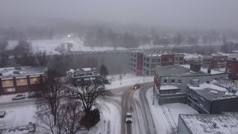 snow covered town of orford, with apartment and businesses on a small lake with a light fog, aerial view