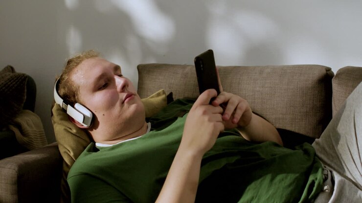 Fyr med hovedtelefoner tjekker sociale medier derhjemme