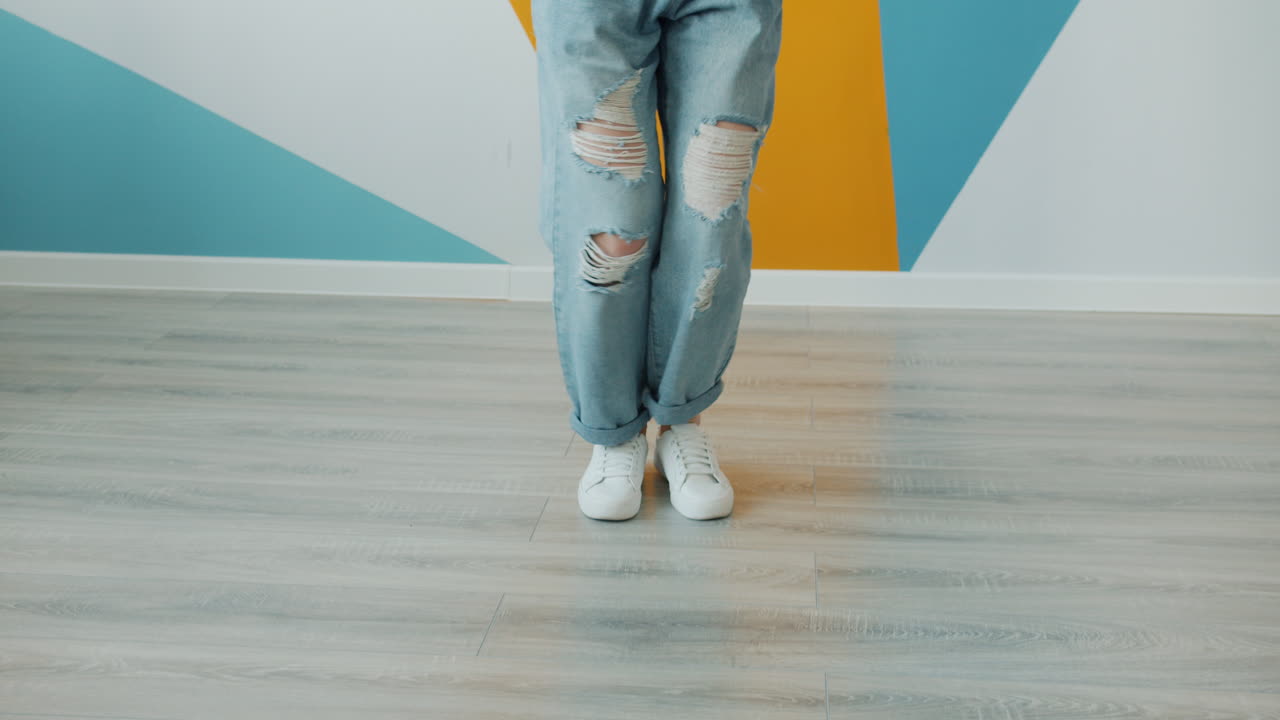 Woman Dancing in Stylish Ripped Jeans and Sneakers