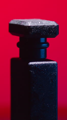 close-up of a black perfume bottle with water droplets