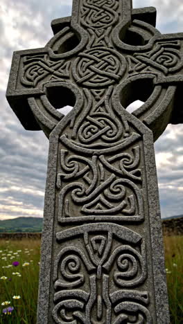 ornate celtic cross with intricate carvings against a cloudy sky