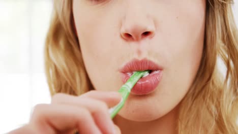 portrait of woman brushing her teeth in bathroom