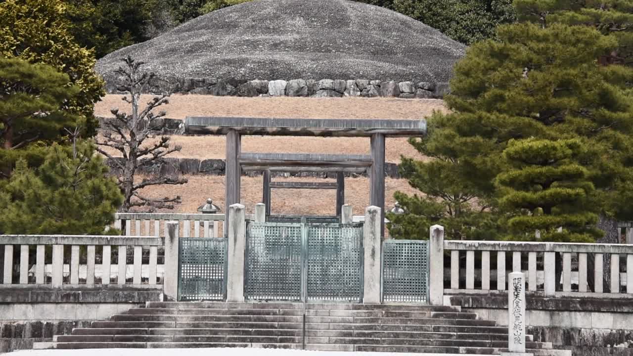 The mausoleum of Emperor Kōmei, father of Emperor Meiji, stands solemnly in Kyoto, Japan, marked by torii gates, symmetrical stonework, and a forested burial mound.