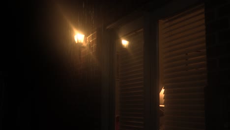 exterior house light glowing on a stormy night.