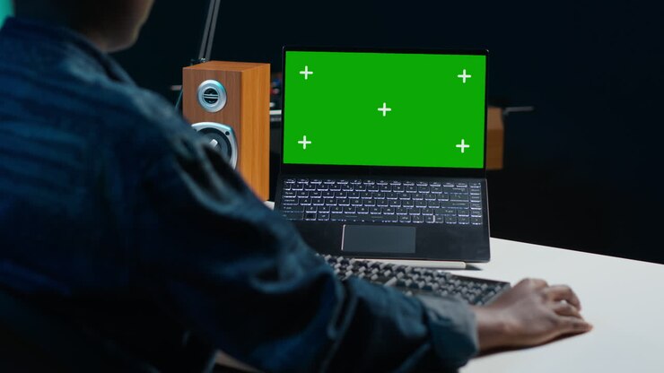 Person, die an einem Laptop mit einem Greenscreen arbeitet