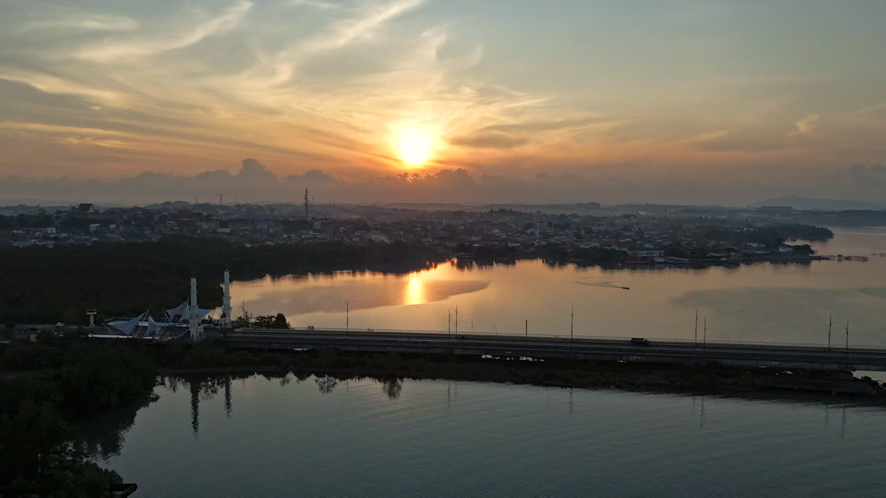 Dramatic hyperlapse drone shot panning over the calm coastal city of Tanjung Pinang during golden hour. Tanjung Pinang, Indonesia (Tanjungpinang, Indonesia)