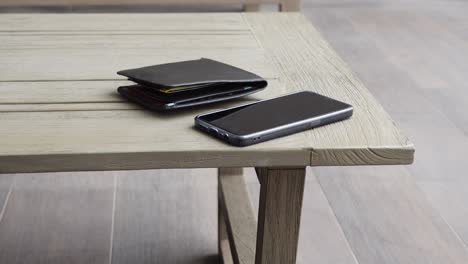 wallet and phone on wooden table