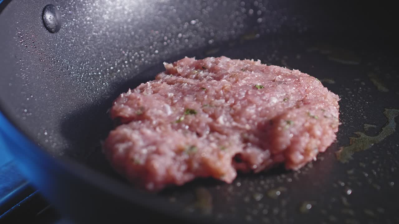 Placing Turkey Burger Patty Into Hot Skillet With Olive Oil For Frying