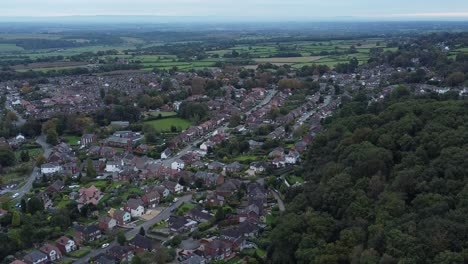 Aerial-view-above-Halton-North-England-coastal-countryside-town-estate-green-space-descend-left-pan