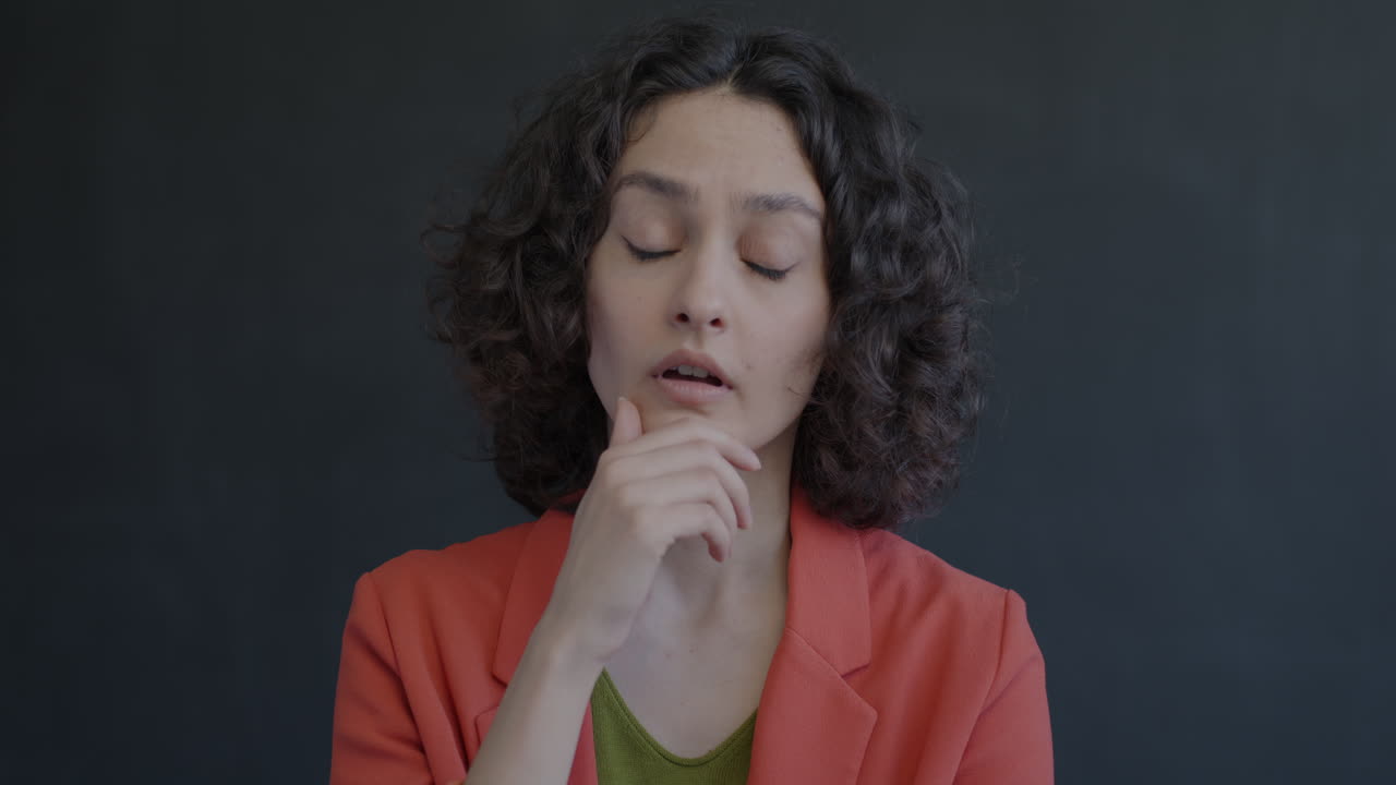 Woman with curly hair, thoughtful expression