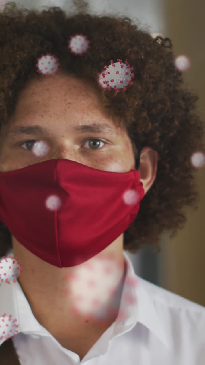 Animation of virus cells over biracial man with face mask