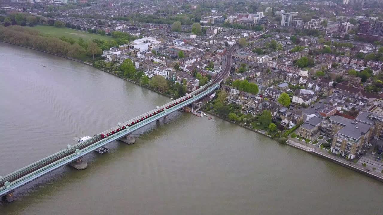 Drone shot of train from London Tube going across a bridge and passing another train.mp4
