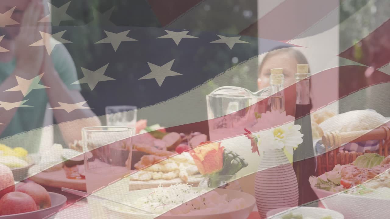 animación de la bandera estadounidense sobre una feliz familia caucásica cenando y orando