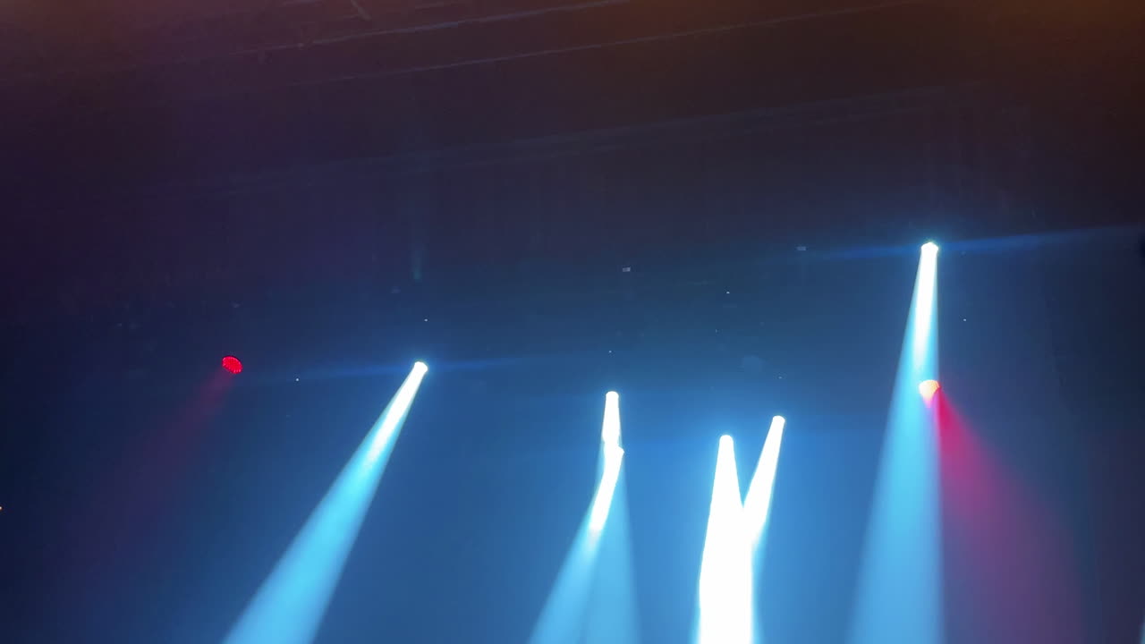 Dynamic stage lighting with colorful beams illuminating a vibrant concert atmosphere