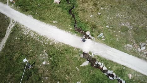 top drone view of mountain path with meadow, someone walks