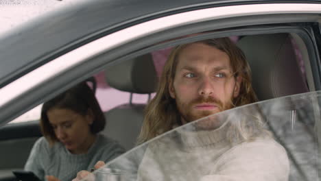 Side-View-Of-A-Couple-Sitting-In-Car-On-A-Winter-Day