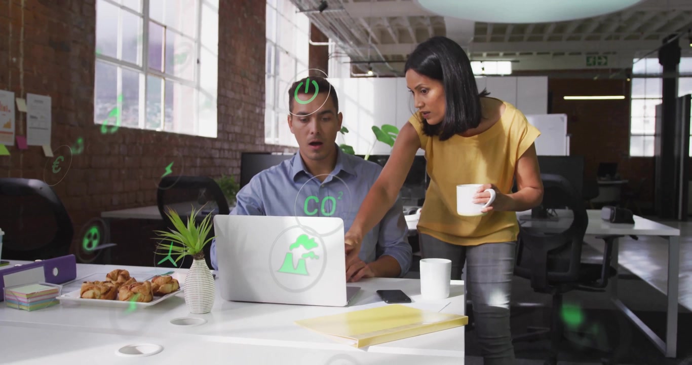 Woman pointing at laptop and activating green eco-icons while man interacting for business planning