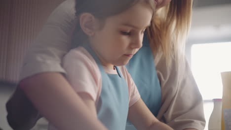 una mujer adulta y una niña bonita están cocinando juntos en la cocina. madre e hija están pasando tiempo juntos.