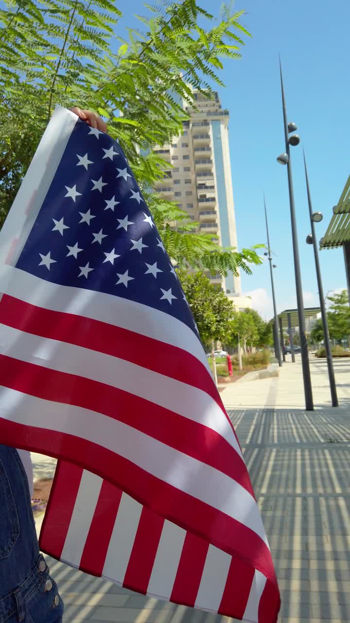 A person holding a red, white, and blue American flag