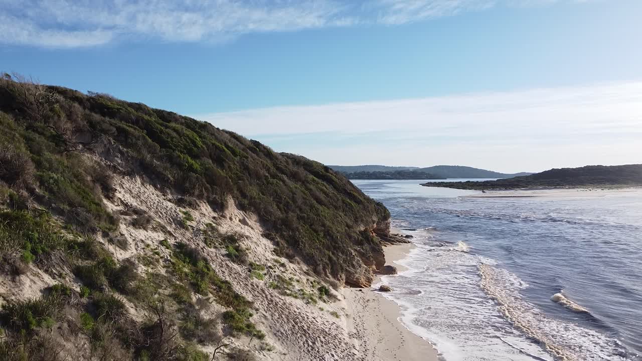 Spokojna scena nadmorska z piaszczystą plażą, bujną roślinnością i delikatnymi falami w Australii Zachodniej.