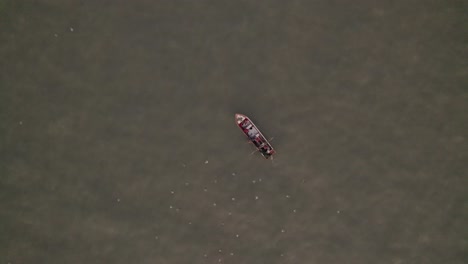 top-down view of a small fishing boat on the caribbean sea setting the fishing nets