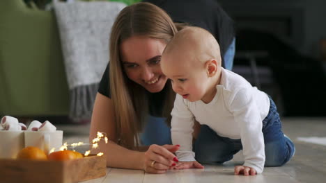 Weinender-Süßer-Kleiner-Junge,-Der-Zu-Hause-Auf-Dem-Boden-Sitzt-Und-Dann-Zu-Seiner-Mutter-Kriecht