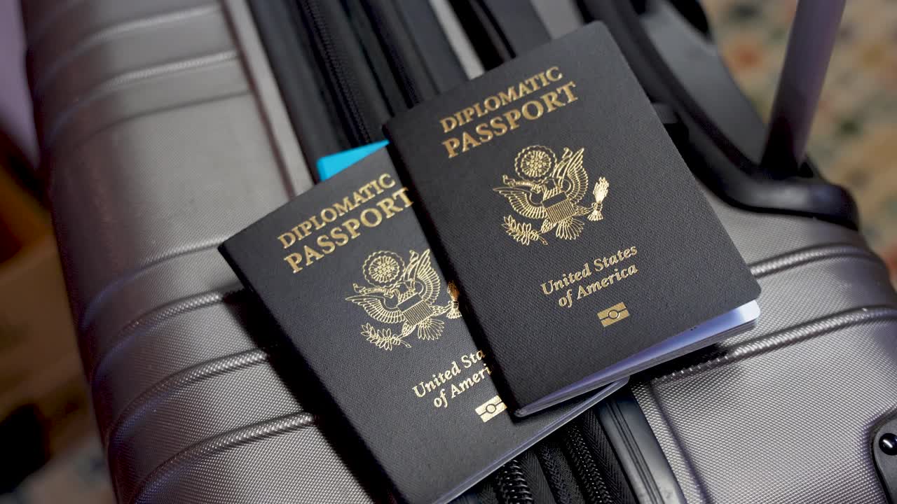 Close up two American diplomatic passports on a suitcase at airport, no person