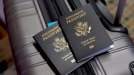 close up two american diplomatic passports on a suitcase at airport, no person