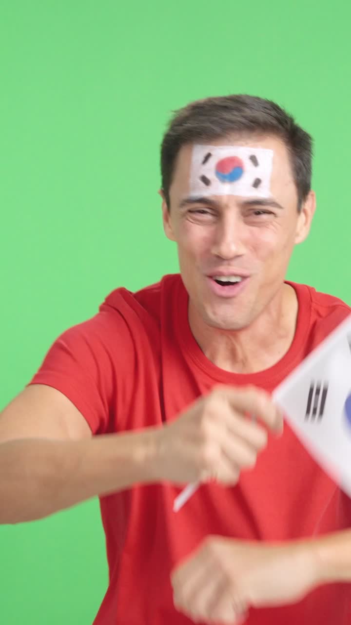 Man cheering for South Korea screaming and waving a national flag