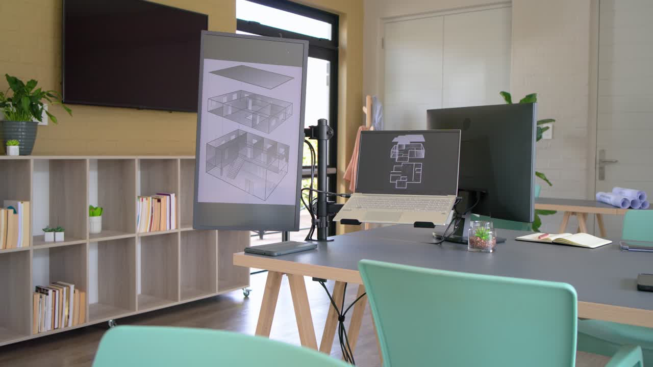 All'inizio, la camera si sposta in avanti e ruota a destra, mostrando il progetto del portatile e i piani arrotolati