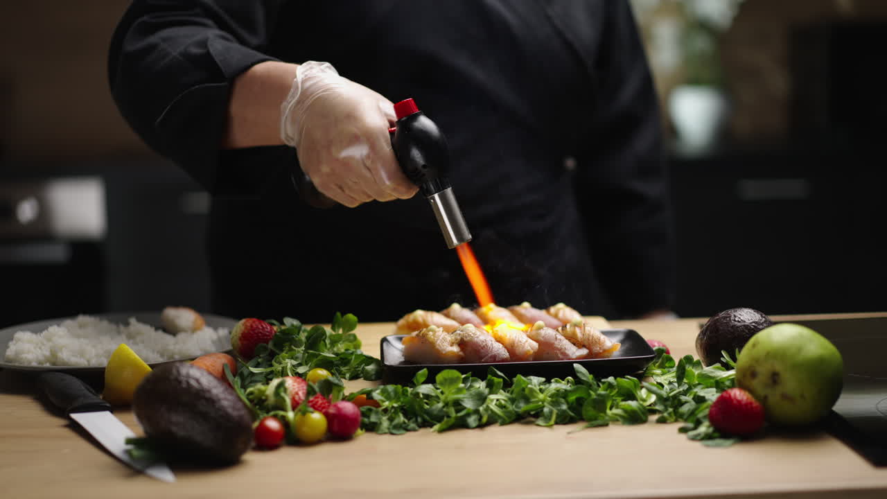 Chef searing sushi with a kitchen torch