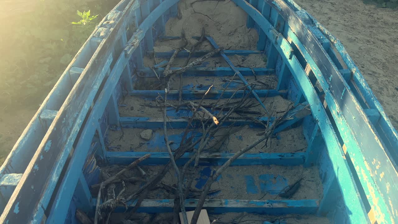 연안 지역에서 휴식을 취하는 은 시 보트, 부분적으로 모래에 묻혀있는 나무 가지의 잔해로, 시 마을의 장식적인 미학을 불러일으킨다.