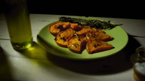 Baked-pumpkin-with-addition-aromatic-herbs.-Rosemary-herb-with-pumpkin-slices