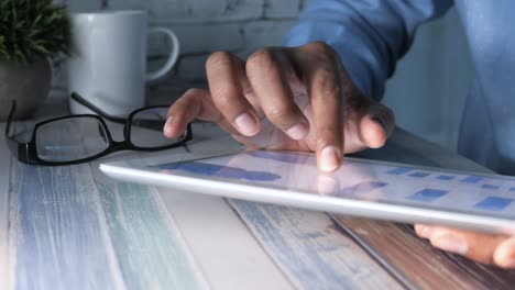 person using a tablet at a wooden table