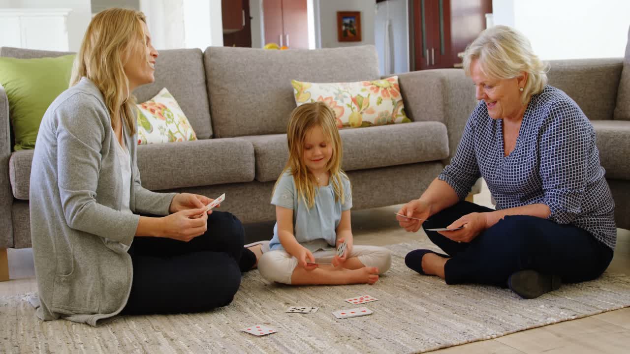 familia de varias generaciones jugando a las cartas en la sala de estar 4k
