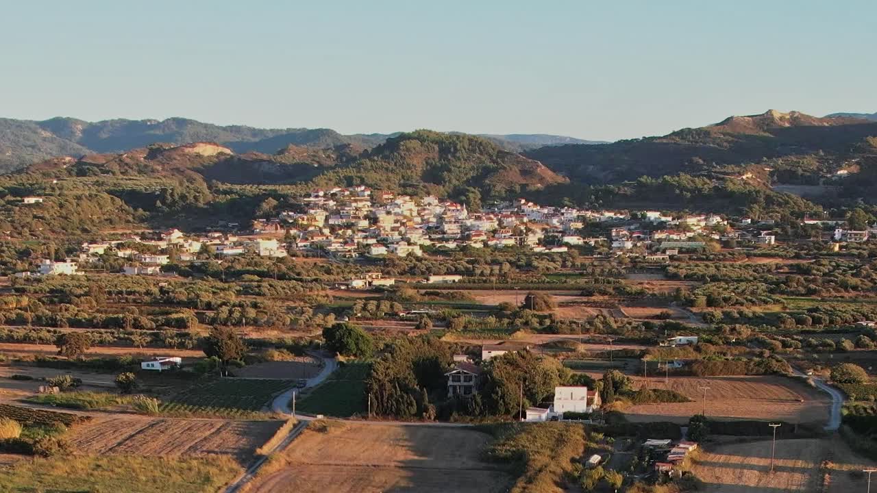 Sonnenuntergang über der Landschaft von Rhodos mit Dorf und Feldern in Griechenland