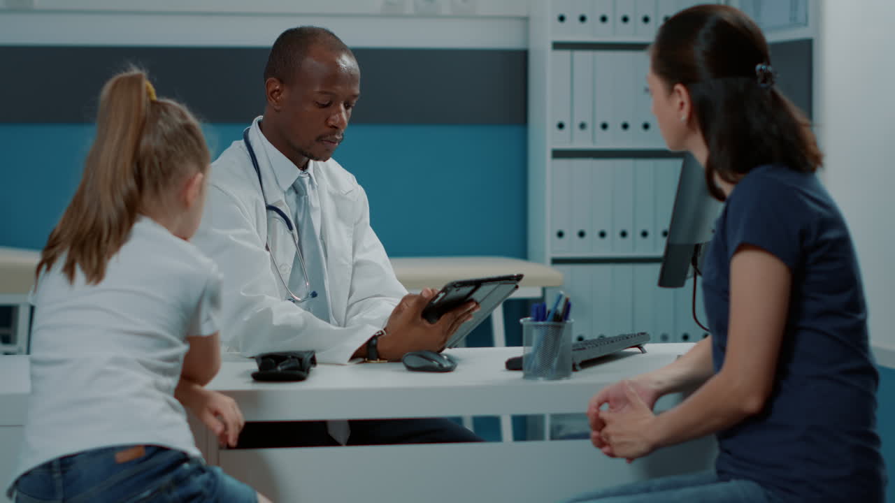 Doctor consulting with child and mother in clinic
