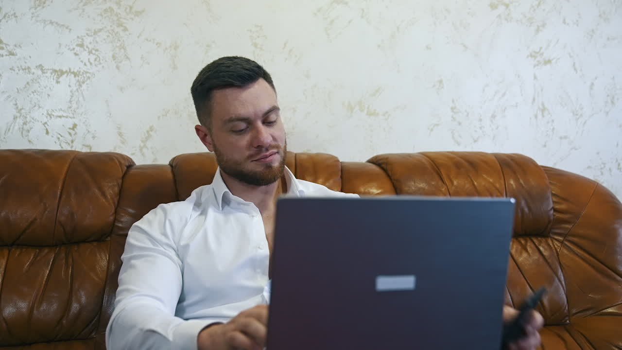 Businessman using smart phone and laptop at hotel room. Portrait of businessman with mobile phone, sitting in the hotel room and using laptop