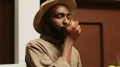 african american man smelling locally grown apples at supermarket