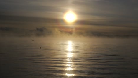 niebla, niebla sobre el mar con puesta de sol