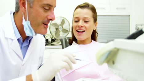 dentista examinando a una paciente femenina con herramientas