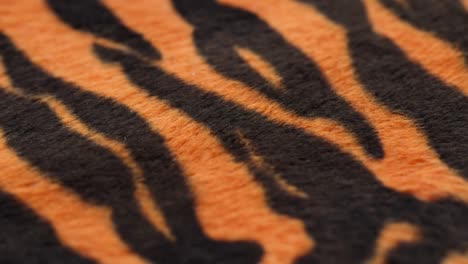 tiger fur fabric close-up. animal print background, striped wool textile. symbol of year 2022. handmade, fashion design and tailoring concept