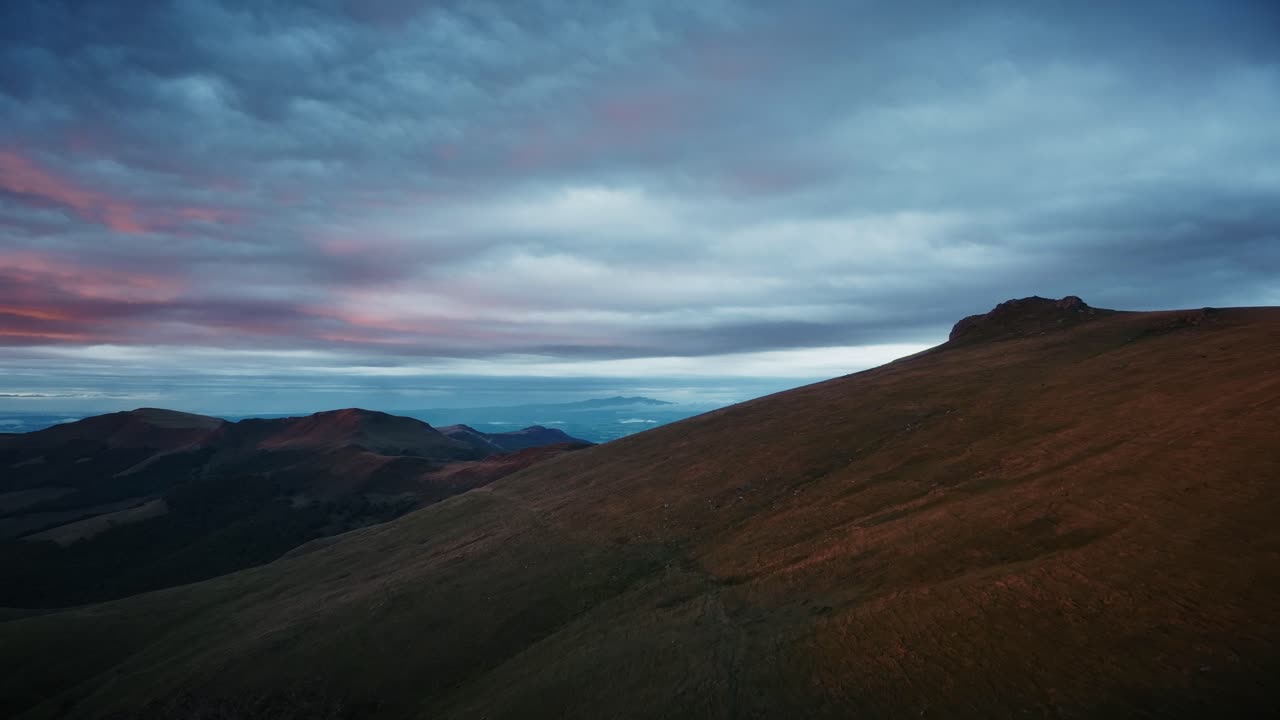 At sunset, aerial view over a mountain, sky threatening a storm is coming, Puy Mary an extinct volcano.