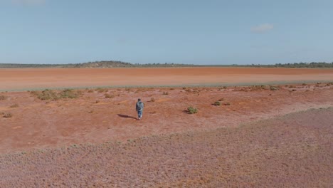 Weitwinkel-Drohnenclip,-Der-Einen-Einsamen-Mann-Zeigt,-Der-Durch-Die-Abgelegene-Australische-Outback-Wüste-Geht