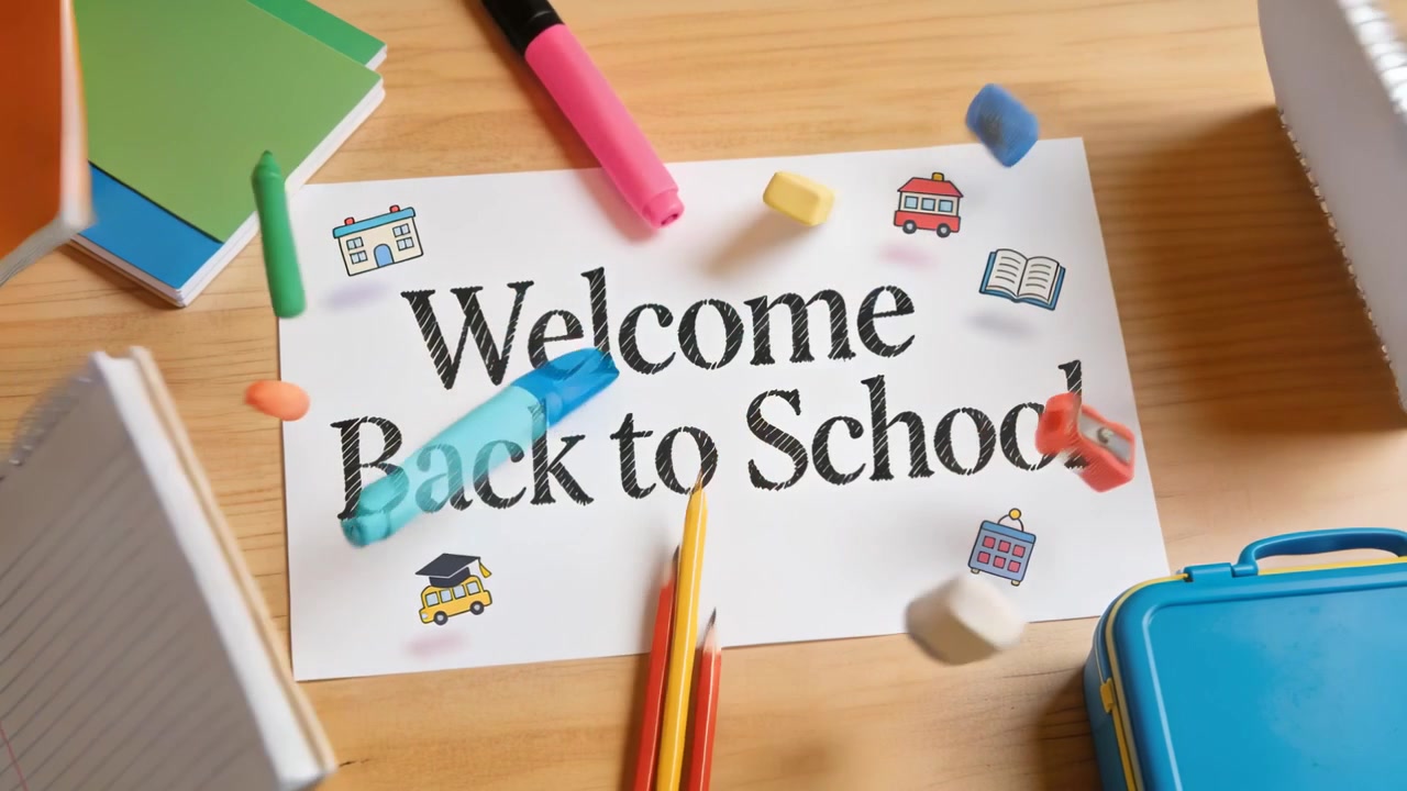 Scattering school supplies around Welcome Back to School sheet on wood table after offscreen jostle