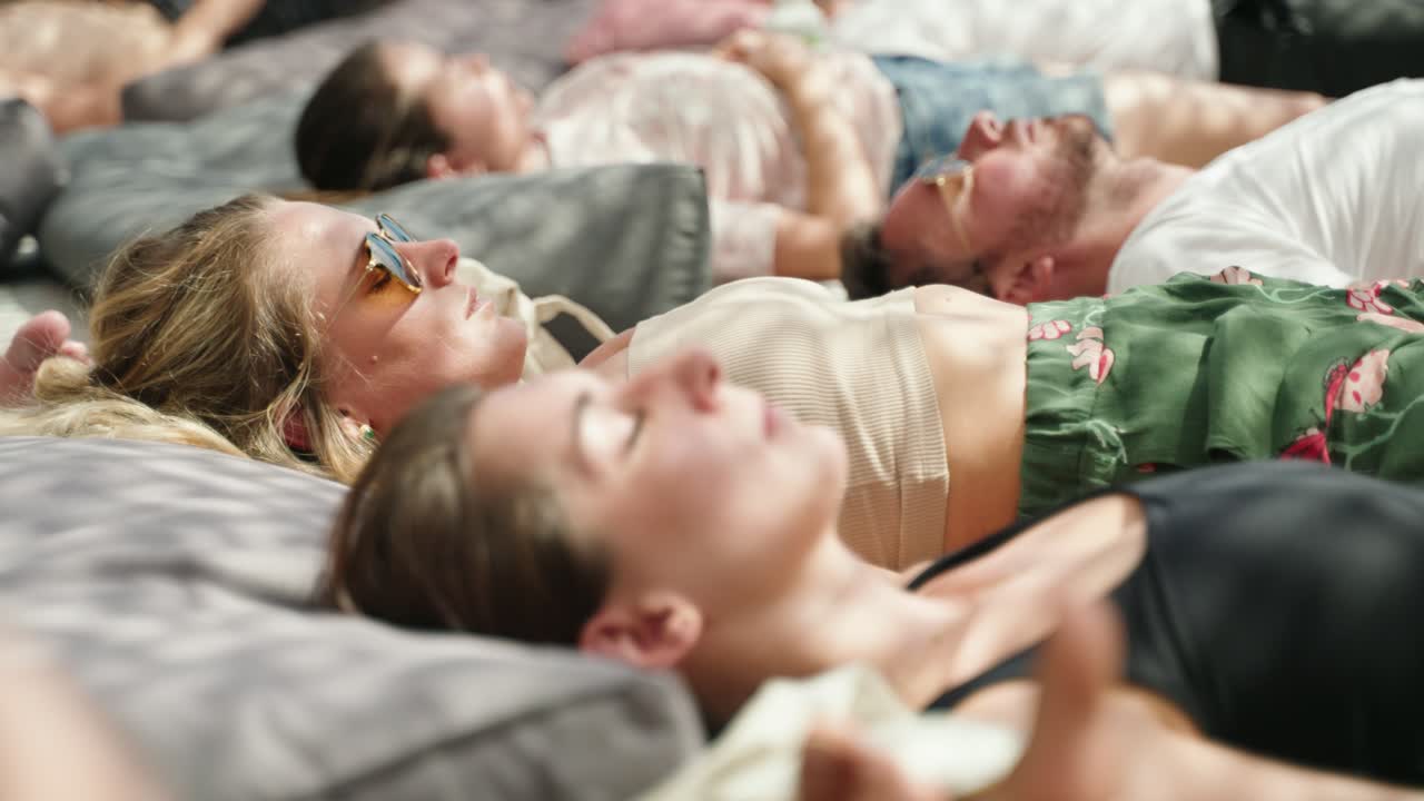 A Group of people is meditating and lying on the floor having a breathwork session